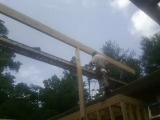 Carpenter setting a ridge beam over a new addition frame — Ice Dam Removal by Roofing Brothers in Cowan