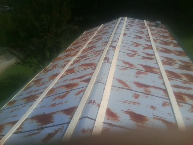 Rusted metal roof panels with new wood purlins before replacement — Storm Damage Roof Repair in Cowan by Roofing Brothers